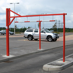 Height restriction barrier with swing top to allow taller vehicles through if required