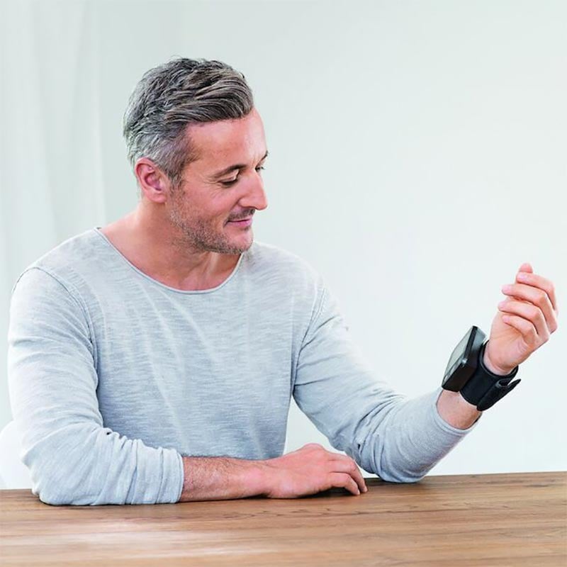 Gentleman wearing a Beurer Medical BC54 bluetooth wrist blood pressure monitor