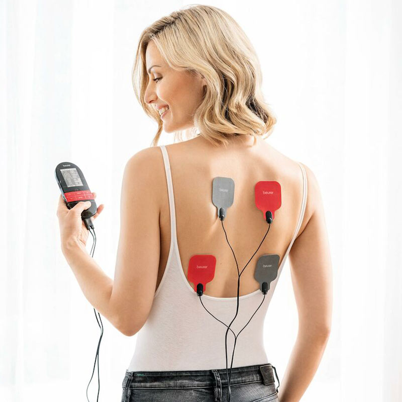 Lady using Beurer TENS machine with 4 electrode pads